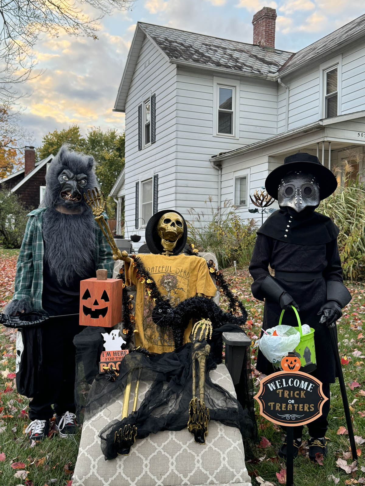 Trick or Treaters posing with a seated skeleton in Lancaster, Ohio